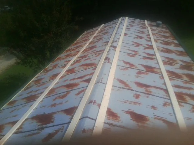Rusted metal roof panels with new wood purlins before replacement — Storm Damage Roof Repair in Woodstock by Roofing Brothers