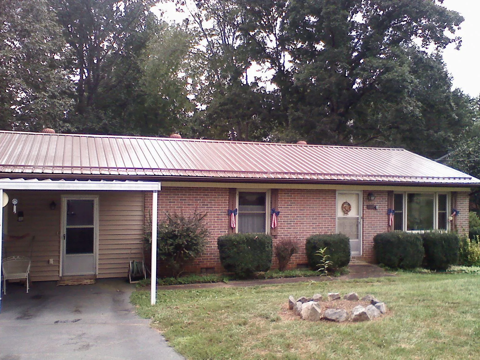 Bronze metal roof and carport on a brick ranch home — Roof Repair work by our crew in Woodstock